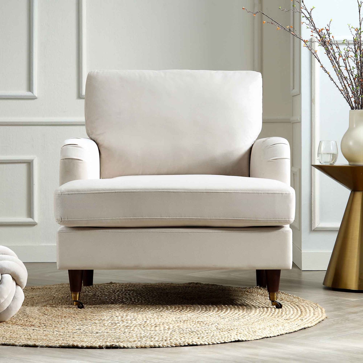 Fauteuil Brigette en velours beige avec pieds à roulettes en laiton antique