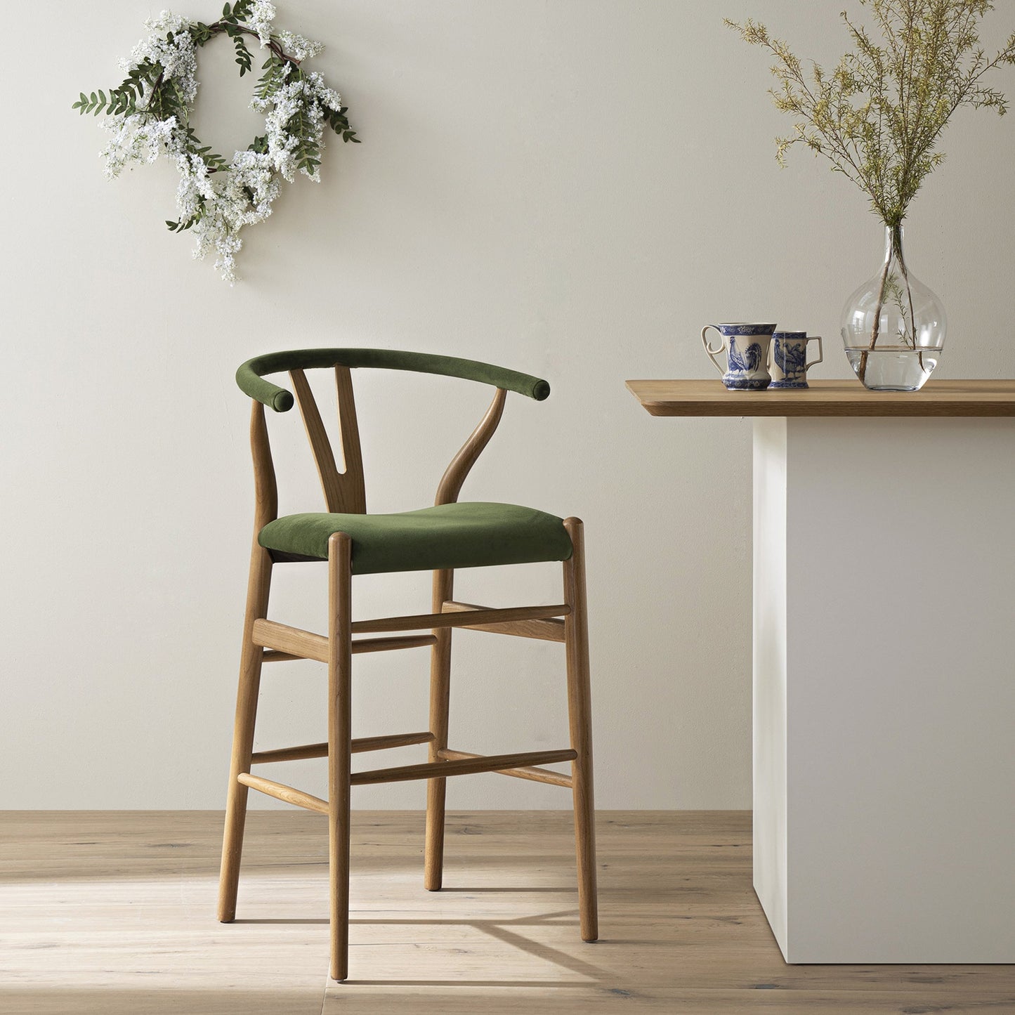 Tabouret de bar rembourré Hansel, velours vert mousse et cadre en noyer clair