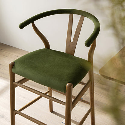 Tabouret de bar rembourré Hansel, velours vert mousse et cadre en noyer clair