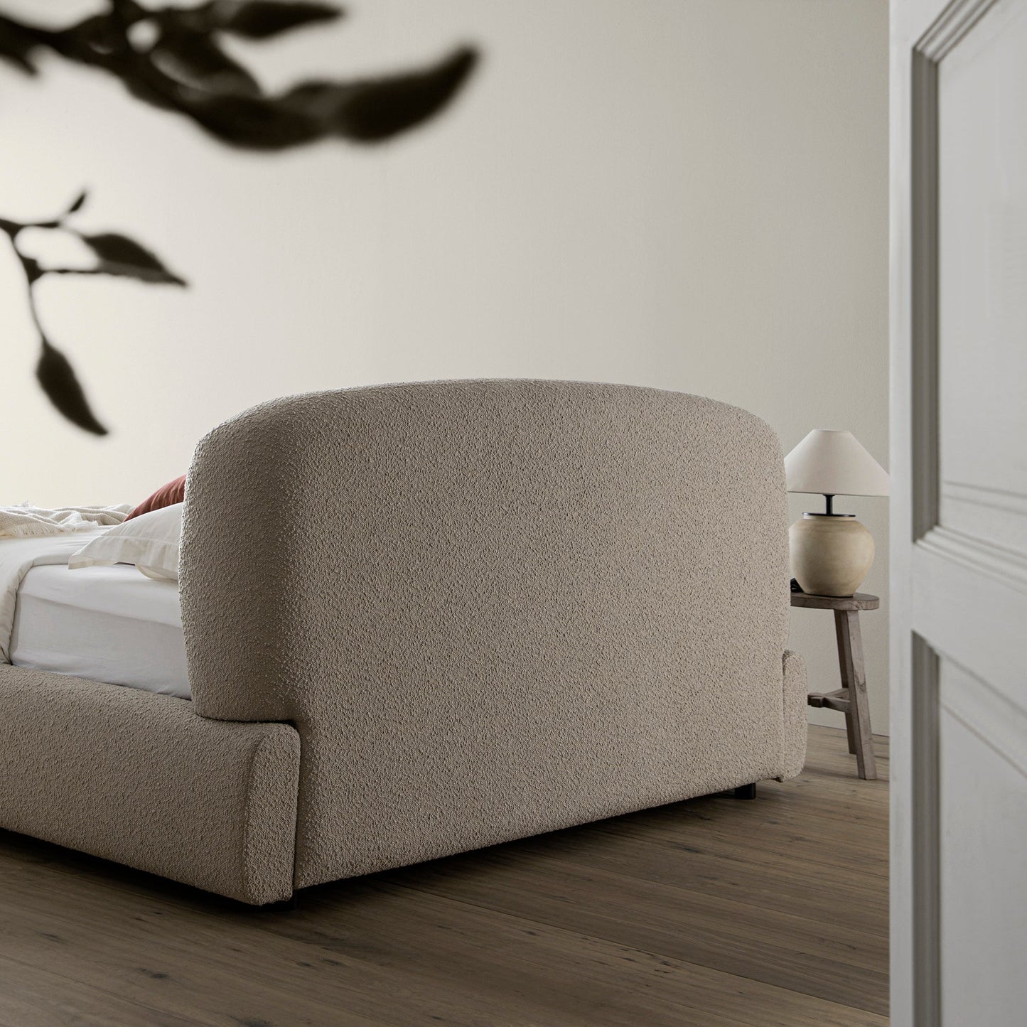 Lit coffre ottoman Constance avec tête de lit ailée, boucle taupe clair